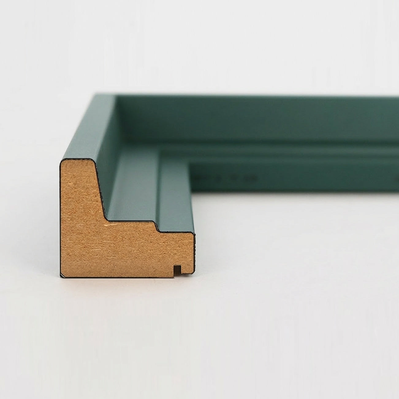 Profil-Querschnitt einer tannengrünen Schattenfugenrahmen-Leiste aus MDF für Leinwandbilder.