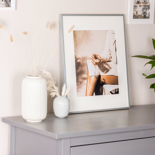 Bilderrahmen Milano aus Aluminium, dekorativ auf Sideboard mit Vasen platziert.