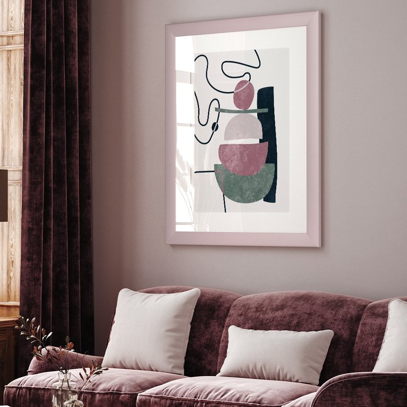 Ein Pastellrahmen hänt in einem modernen Wohnzimmer in Pastellrosa über einer Couch mit einem abstrakten Gemälde gerahmt