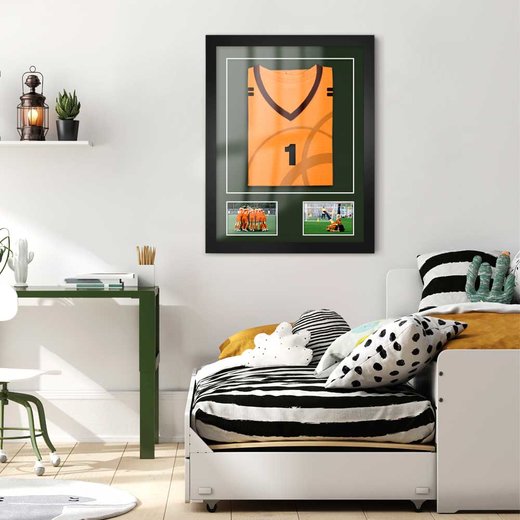 Ein Trikotrahmen in Schwarz mit gerahmten Trikot und zwei Sport Fotos in einem modernen Kinder oder Jugendzimmer