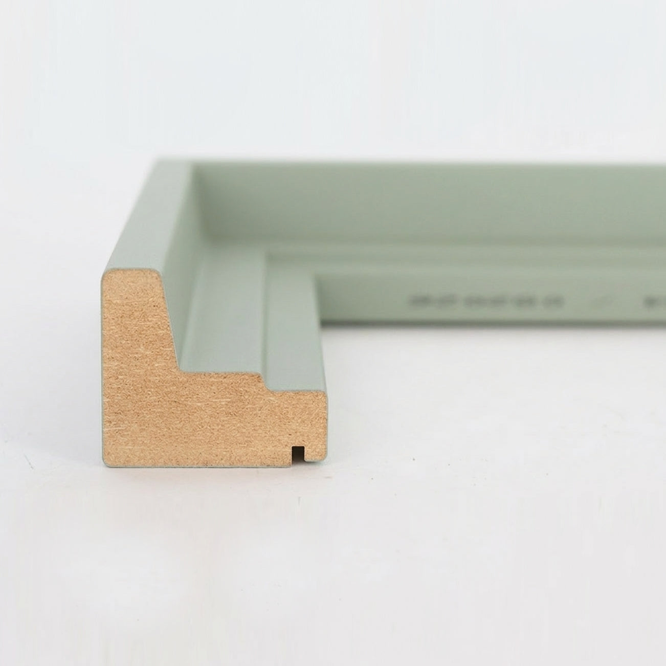 Profil-Querschnitt einer pastellgrünen Schattenfugenrahmen-Leiste aus MDF für Leinwandbilder.