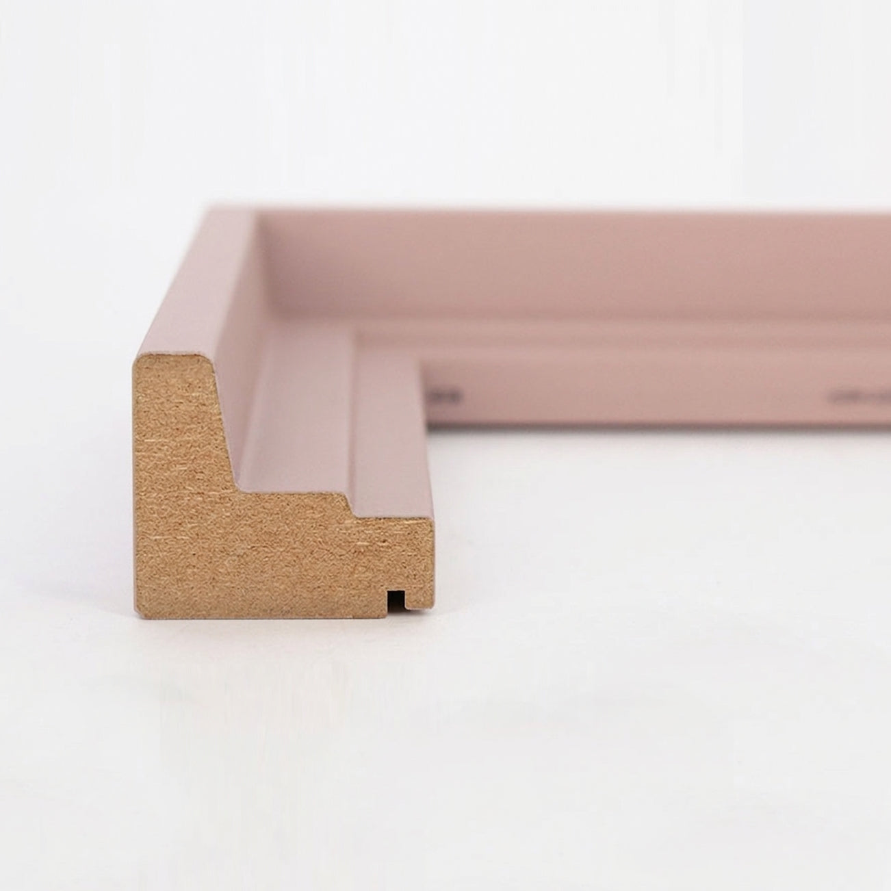 Profil-Querschnitt einer pastellrosa Schattenfugenrahmen-Leiste aus MDF für Leinwandbilder.