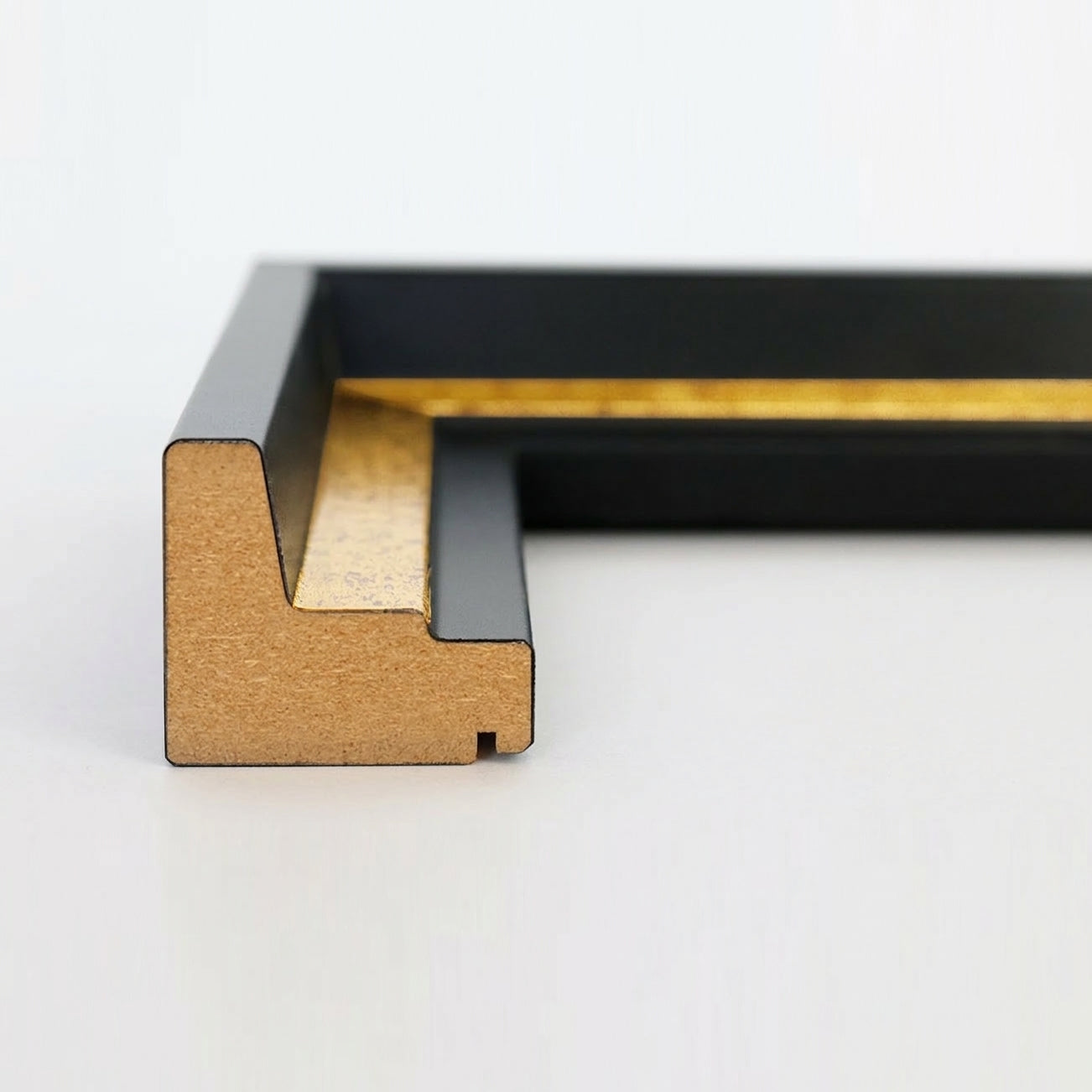Profil-Querschnitt einer schwarz-goldenen Schattenfugenrahmen-Leiste aus MDF für Leinwandbilder.