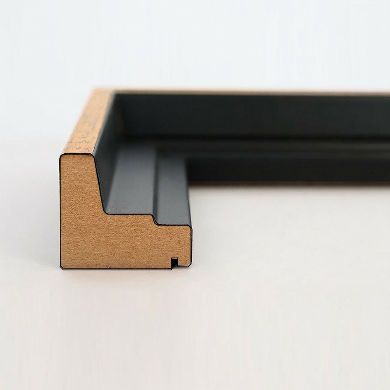 Profil-Querschnitt einer schwarz-goldenen Schattenfugenrahmen-Leiste aus MDF für Leinwandbilder.